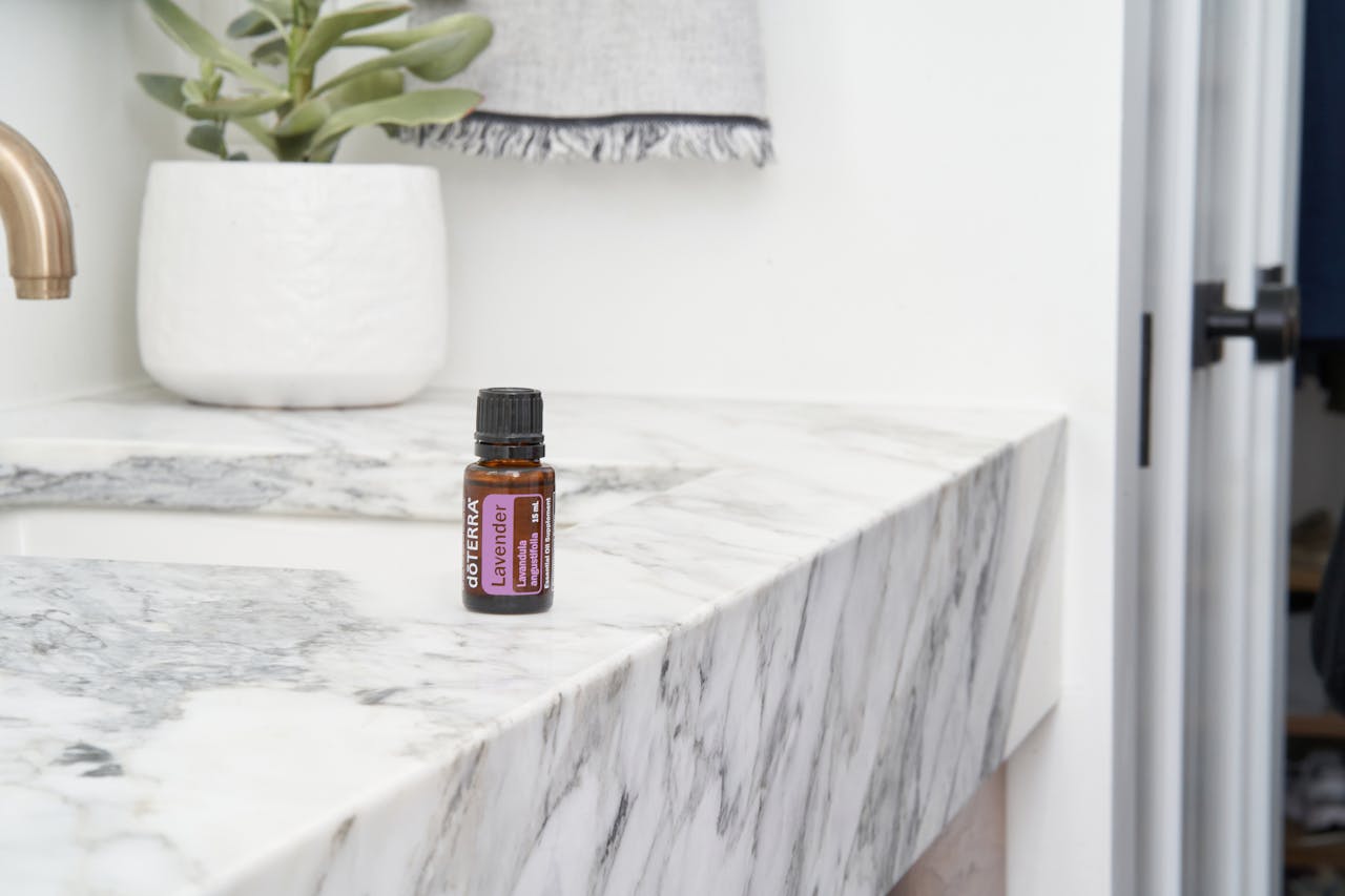 A doterra lavender essential oil bottle on a marble countertop with a sleek, modern look.